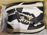a pair of black and white sneakers in a box