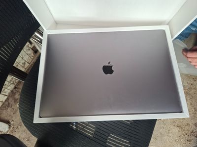 une boîte contenant un ordinateur portable Apple, posée sur une table