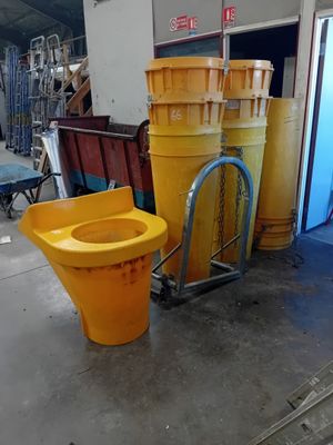 des toilettes jaunes et un seau jaune dans un entrepôt