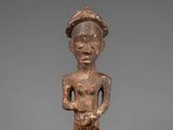 a wooden statue of a man with a hat on his head