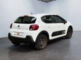 the small white car is parked in a large white room