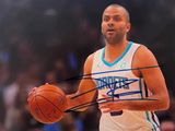 photo dédicacée d'un basketteur tenant un ballon de basket devant un public