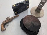 two hats, a hat case, a gun and a hat on a table