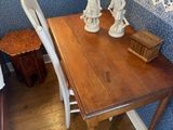 a wooden table with two white chairs in the corner of the room