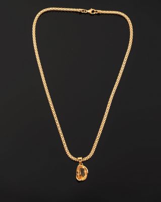 un collier en or avec une pièce de monnaie sur une chaîne