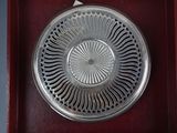 a silver plate in a red box on a table
