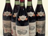 six bouteilles de vin sont alignées sur une surface blanche