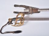 un très vieux pistolet et une paire de ciseaux posés sur une surface blanche