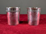 two silver cups on a red table cloth