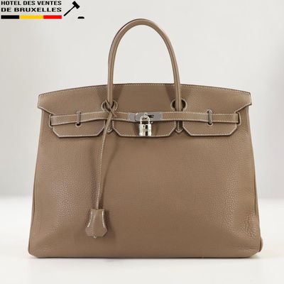 un sac à main en cuir marron muni d'un fermoir métallique sur la poignée