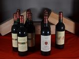several bottles of wine are lined up on a red table cloth