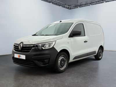La camionnette blanche est garée dans une grande pièce.