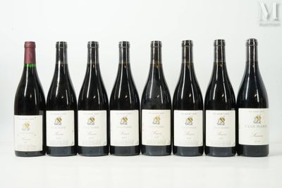 six bouteilles de vin sont alignées sur une table