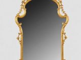 an ornately carved mirror with a gold frame on a white background