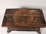 an old wooden table with a circular design on the top of it