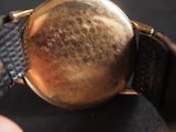 a close up of a gold watch with a black strap