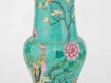 une image représentant un vase vert orné d'un oiseau et de fleurs
