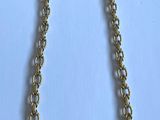 un collier à chaîne en or avec un fermoir sur fond blanc