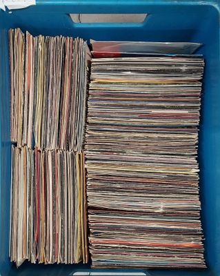 beaucoup de disques dans une boîte bleue posée sur la table