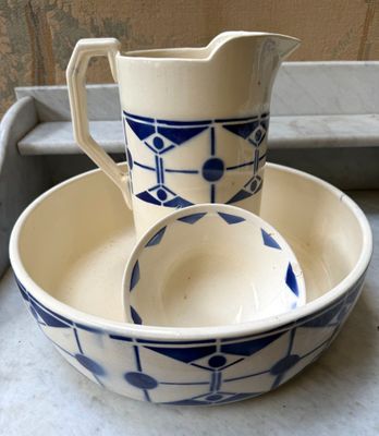 two bowls and a pitcher sitting on a counter