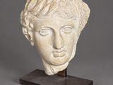 a white marble head of a woman on a wooden base