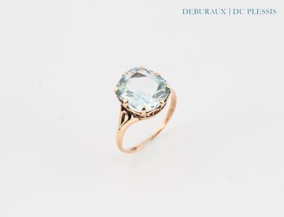 a close up of a gold ring with a blue topaz stone