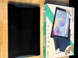 une tablette posée sur une table, à côté d'une boîte