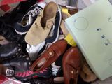 une pile de chaussures et un sac par terre
