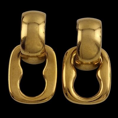 une paire de boucles d'oreilles en or avec des maillons ovales sur fond noir