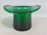 une image représentant un bol en verre vert posé sur une surface blanche