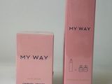a pink box with a bottle of perfume next to it on a white surface
