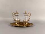 pair of silver and gold plated sugar and pepper shakers on a tray