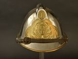 un casque orné d'une pièce d'or, posé sur un socle