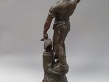 statue of a man with a hammer in his hand on top of a rock