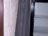 an open refrigerator with a black cover next to it