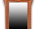 On voit un miroir richement sculpté sur fond blanc.