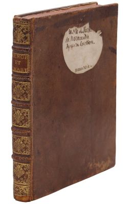 un vieux livre à la couverture brune posé sur une surface blanche