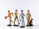 three figurines of a man and a dog on a white surface