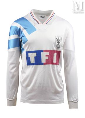 un gros plan sur un maillot de foot blanc orné d'une bande bleue et rouge