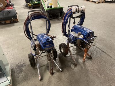deux pulvérisateurs de peinture sans air posés par terre dans un entrepôt