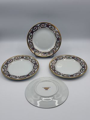 three plates and a saucer are sitting on a table