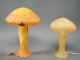 deux lampes en forme de champignon, l'une jaune et l'autre orange, posées sur une surface grise