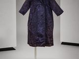 une photo d'un manteau violet posé sur un portant dans une pièce