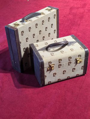 two suitcases that are sitting on a pink surface
