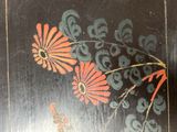 a picture of a painting of flowers on a black surface