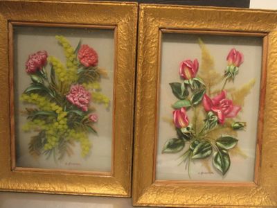 two framed pictures of flowers in a gold frame