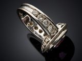 a close up of a ring with diamonds on a black surface