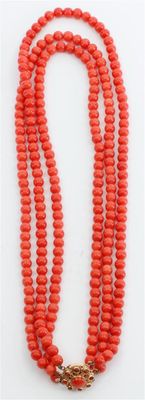 un collier de perles rouges muni d'un fermoir en or