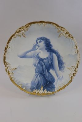 an image of a blue and white plate with a woman on it