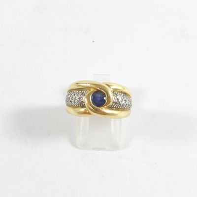 Gros plan sur une bague en or ornée d'une pierre bleue